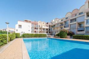 a swimming pool in front of a apartment building at studio cabine tous cocooning in Gruissan