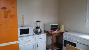 uma cozinha com um liquidificador e um micro-ondas numa mesa em Maison dans Quartier Calme em Lacanau-Océan