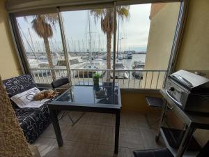a living room with a table and a view of a marina at studio cabine tous cocooning in Gruissan +6 photos