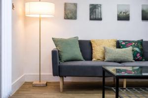 a living room with a blue couch and a lamp at Ward St Residence - Parking - Lpool City Centre in Liverpool +32 photos