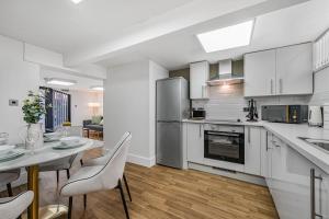 a kitchen with white cabinets and a table and chairs at Ward St Residence - Parking - Lpool City Centre in Liverpool