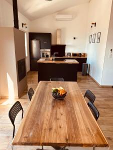 a wooden table with a bowl of fruit on it in a kitchen at Duplex face à la mer in Saint-Florent
