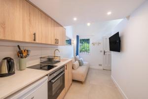 a kitchen with a stove top oven next to a couch at Studio in a residence with pool - Saint-Tropez in Saint-Tropez
