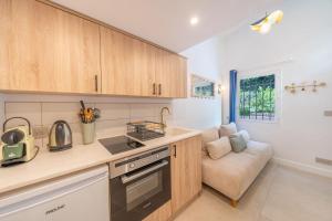 a kitchen with wooden cabinets and a couch at Studio in a residence with pool - Saint-Tropez in Saint-Tropez