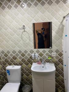 a person taking a picture of a bathroom with a toilet and sink at Hotel KASIMOV in Podan +34 photos