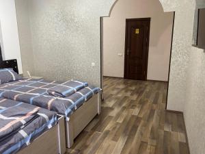 a room with two beds and a mirror and a door at Hotel KASIMOV in Podan