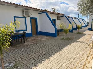 a blue and white building with a table in front of it at Nefama Pensao in Ourique