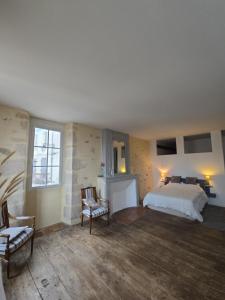 a bedroom with a bed and two chairs in it at B&B Le MONSEG 33 in Monségur +2 photos