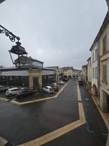 a city street with cars parked in a parking lot at B&B Le MONSEG 33 in Monségur