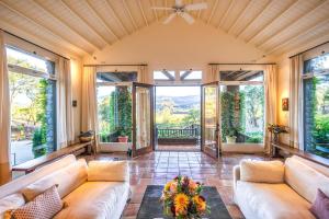 a living room with a couch and large windows at Morlet Hilltop House in St. Helena