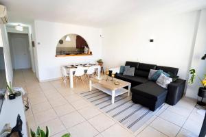 a living room with a black couch and a table at Estrella del Sur in Torremolinos
