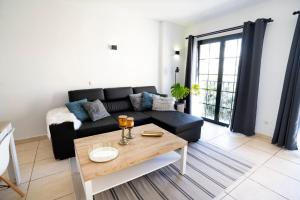 a living room with a black couch and a table at Estrella del Sur in Torremolinos