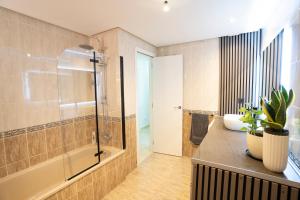 a bathroom with a shower and a tub and a sink at Estrella del Sur in Torremolinos