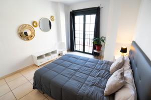 a bedroom with a blue bed and a window at Estrella del Sur in Torremolinos +17 photos