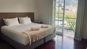 a bedroom with a bed with two towels on it at Maribel's Place in Funchal