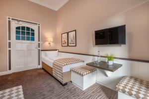a hotel room with a bed and a flat screen tv at Hotel Strandschlösschen in Travemünde
