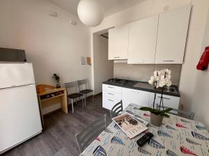 a kitchen with a table and a white refrigerator at Villa Lucia in Caorle