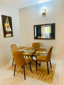 a dining room with a glass table and chairs at KMC Guest House in Douala