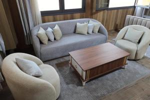 a living room with a couch and two chairs and a coffee table at Villa aya in Oujda +2 photos