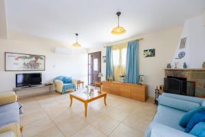 a living room with a blue couch and a tv at Villa Alonia in Simou