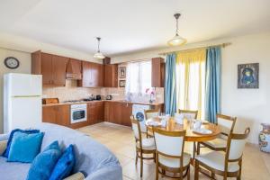 a kitchen and dining room with a table and a couch at Villa Alonia in Simou