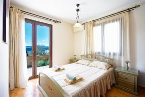 a bedroom with a bed and a large window at Villa Alonia in Simou +17 photos