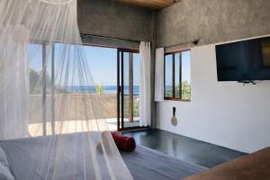 a bedroom with a bed with a view of the ocean at Casa Moorea - Steps to Beach in Puerto Escondido