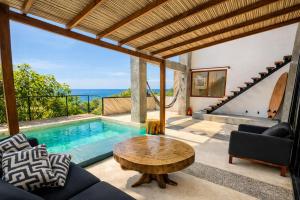 a living room with a table and a pool at Casa Moorea - Steps to Beach in Puerto Escondido