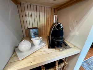 a coffee maker and cups on a wooden shelf at The Family Cottage in Delta +11 photos