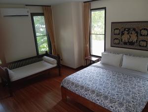a bedroom with a bed and a couch and two windows at Villa La Origin Life in Phuket
