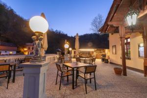 a restaurant with tables and chairs and a statue on a pole at Resort U Jelena in Křivoklát