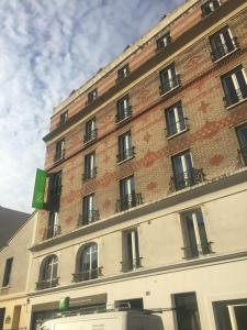 a building with a clock on the front of it at Ibis Styles Paris Place d'Italie - Butte Aux Cailles in Paris