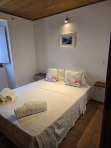 a bedroom with a large white bed with two pillows at Casa Pedra da Foz in Odeceixe