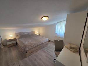 a bedroom with a bed and a chair in a room at Apartments & Rooms Nensi in Baška