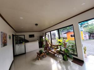 a man sitting on a bench in a room with windows at Tiza Manor Inn in Roxas City