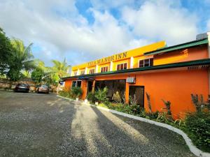 an orange building with cars parked in front of it at Tiza Manor Inn in Roxas City
