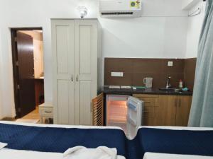 a kitchen with a bed and a sink in a room at Leela Homes - Backpacker's Nest in Arpora