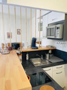 a kitchen with a sink and a microwave at Le Val Claret in Antibes