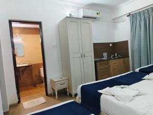 a small bedroom with two beds and a mirror at Leela Homes - Backpacker's Nest in Arpora