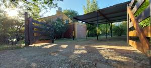 an open gate with a fence in front of a building at Cabañas Desde Las Estrellas in Merlo