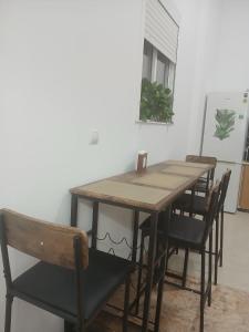 a wooden table and chairs in a room at Habitaciones turísticas copitos in Gandía