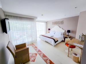 a bedroom with a large bed and a desk and a table at Hotel M Boutique in Villeta