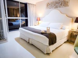a bedroom with a large bed and a window at Hotel M Boutique in Villeta