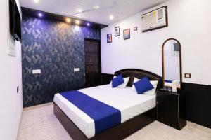 a bedroom with a bed with blue pillows at Hotel In Varanasi in Varanasi