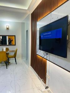 a large flat screen tv hanging on a wall at KMC Guest House in Douala