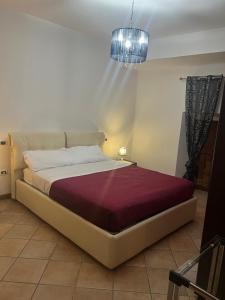 a bedroom with a large bed with a purple blanket at La Petite Maison Rieti in Rieti
