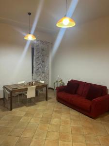 a living room with a red couch and a table at La Petite Maison Rieti in Rieti