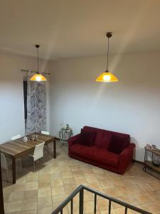 a living room with a red couch and a table at La Petite Maison Rieti in Rieti