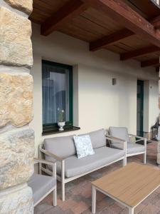 a patio with two benches and a table at Hotel Garni Klaret in Valtice