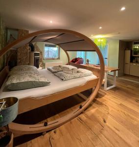 a large wooden bed frame in a room at BioNestlein Premium Apartments mit Biosauna, Wintergarten & exklusiver Bio-Verpflegung in Löffingen